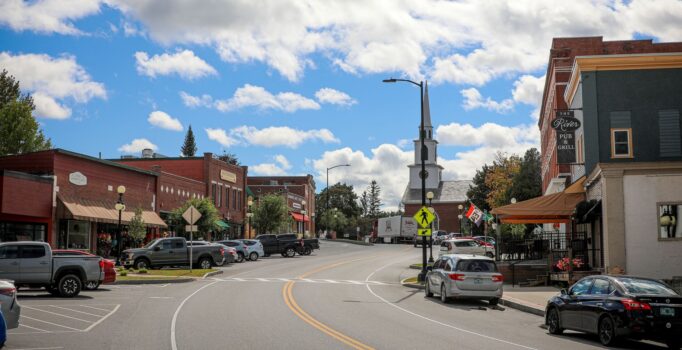 A church is the centerpiece of this image of a small town with buildings on both sides of the street.