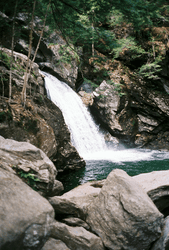 A small waterfall surrounded by large rocks.