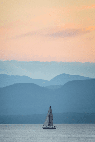 A sailboat on a lake at sunset.