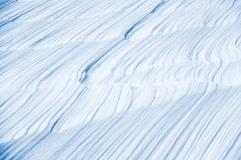 A pattern of vertical lines in the texture of snow.