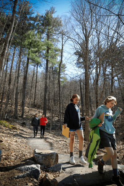 Young people hike a trail in Vermont.