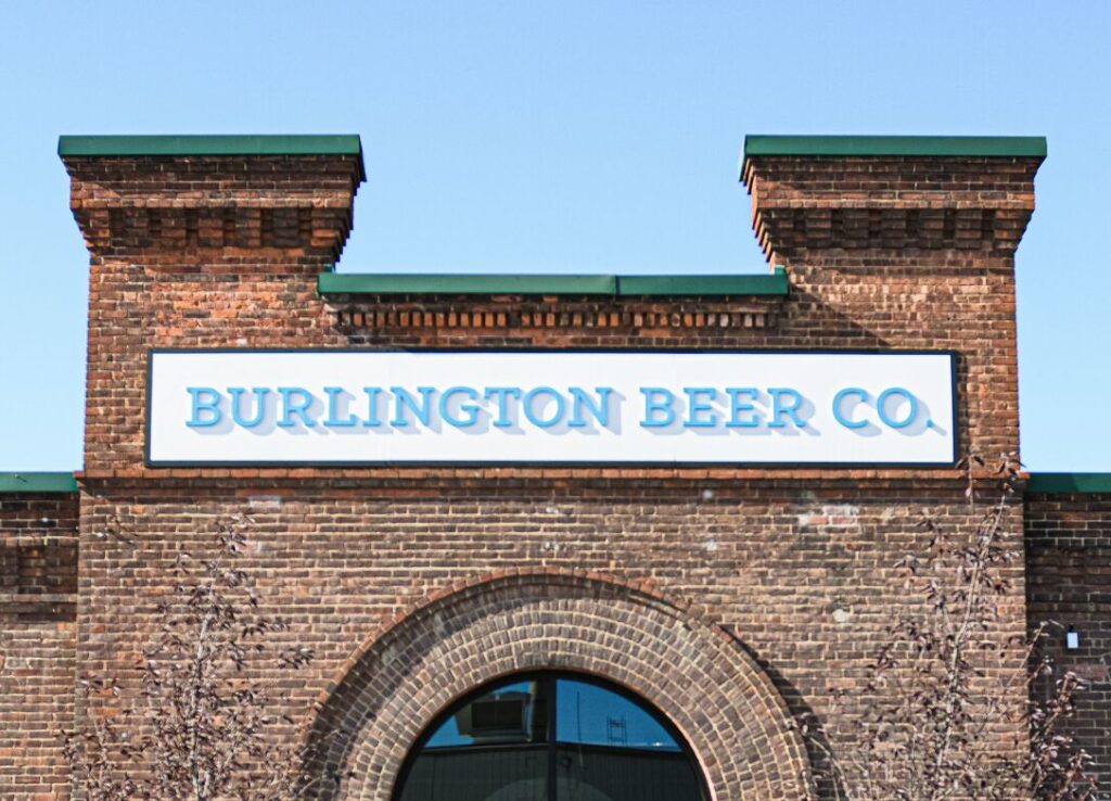 A brick building has a sign that reads Burlington Beer Company.