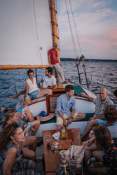 People sit and talk to each other on a sailboat.