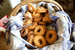 A basket of fresh donuts indoors.