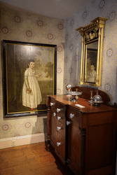 The interior of a room is seen with Victorian decorations and an old desk.