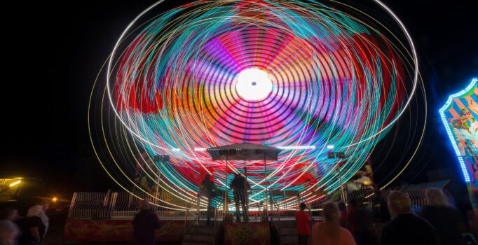 Night scene at the fair with a spinning carnival ride.