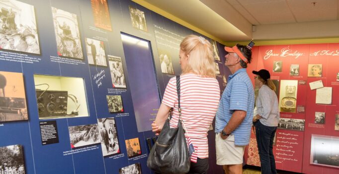People stop to read information on the walls of a historical site.