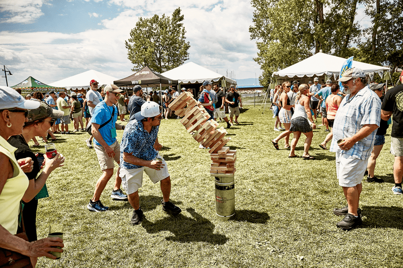 A group of people play jenga at an outdoor festival.
