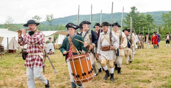 Revolutionary War reenactors marching by.