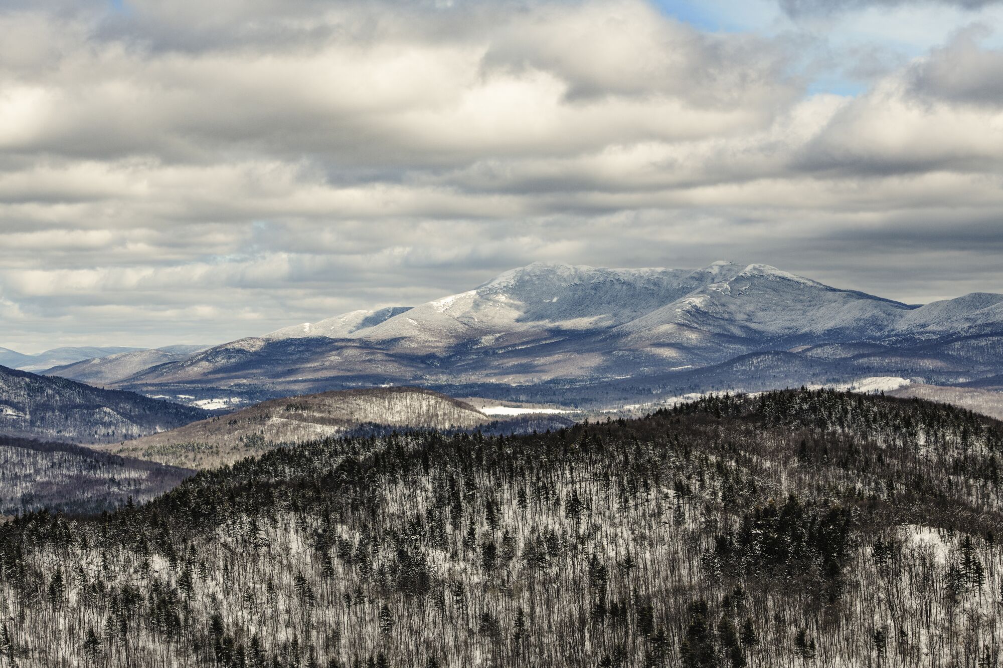 A snow topped mountain with foreboding skies in Vermont.