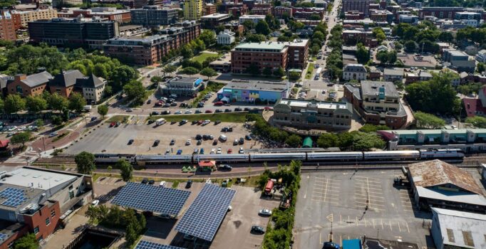 A view from above of downtown Burlington where a train is moving across the tracks.