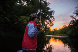 A young person casts a fishing line.
