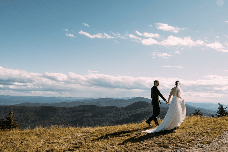 A couple poses for wedding photos on a summit in Stowe, Vermont.