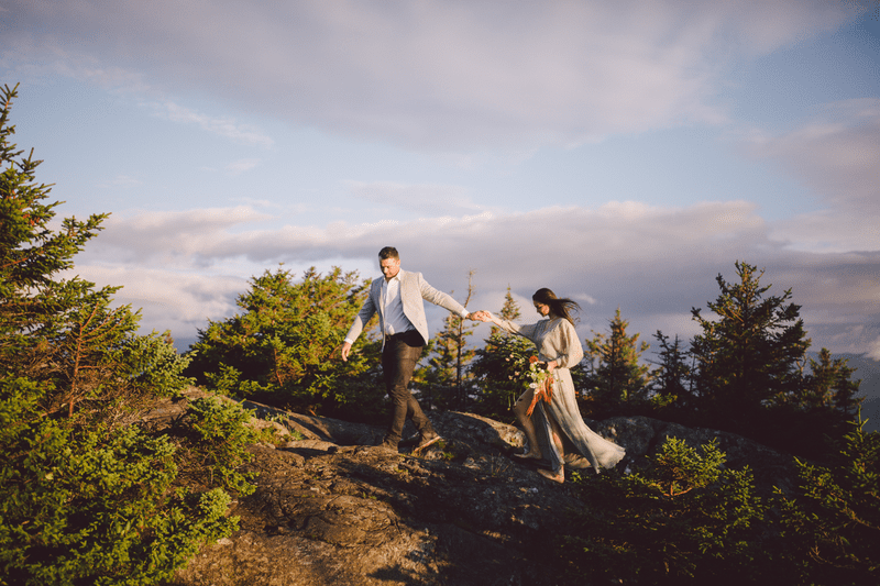 A couple poses for engagement photos on the summit of Stowe Pinnacle.