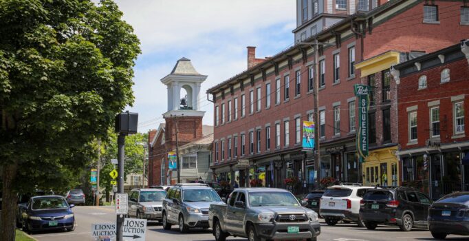 Brick buildings line a town street.