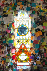 Paper notes surround a stained-glass window depicting a dog with light shining through.