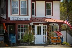 A general store with a sign reading “East Poultney General Store” seen from outside in the fall.