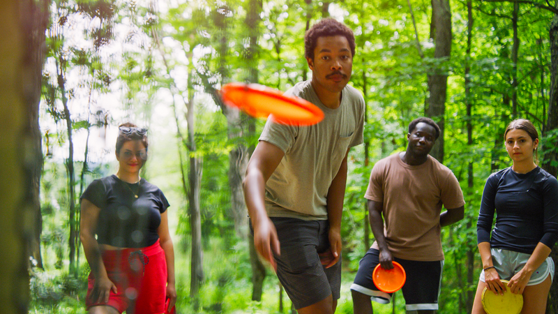 A group of individuals playing frisbee golf in Waterbury, Vermont.