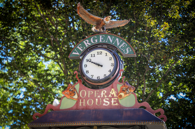 Vergennes Opera House clock decorated with sculptures of theatrical masks and an eagle made of metal.