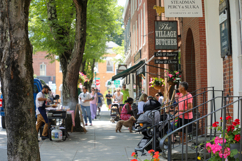 The busy downtown street of Woodstock, Vermont, donning street food, and families.