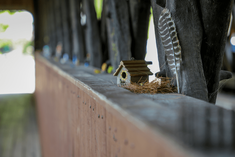 Tiny birdhouse arrangement along a covered bridge.