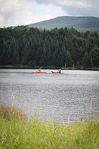 Two people kayak on a lake.