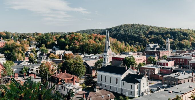 Seen from above, a rural town nestled among the trees on a warm and sunny day.