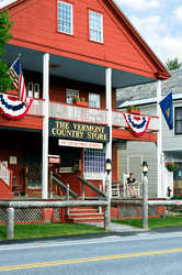 The exterior of the Vermont Country Store building. The building is red and has a porch and balcony.