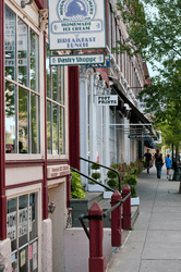 Storefronts along a sidewalk in a downtown area.