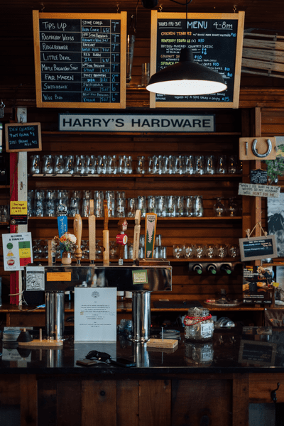 An empty black bar with beer taps and glasses stacked behind.