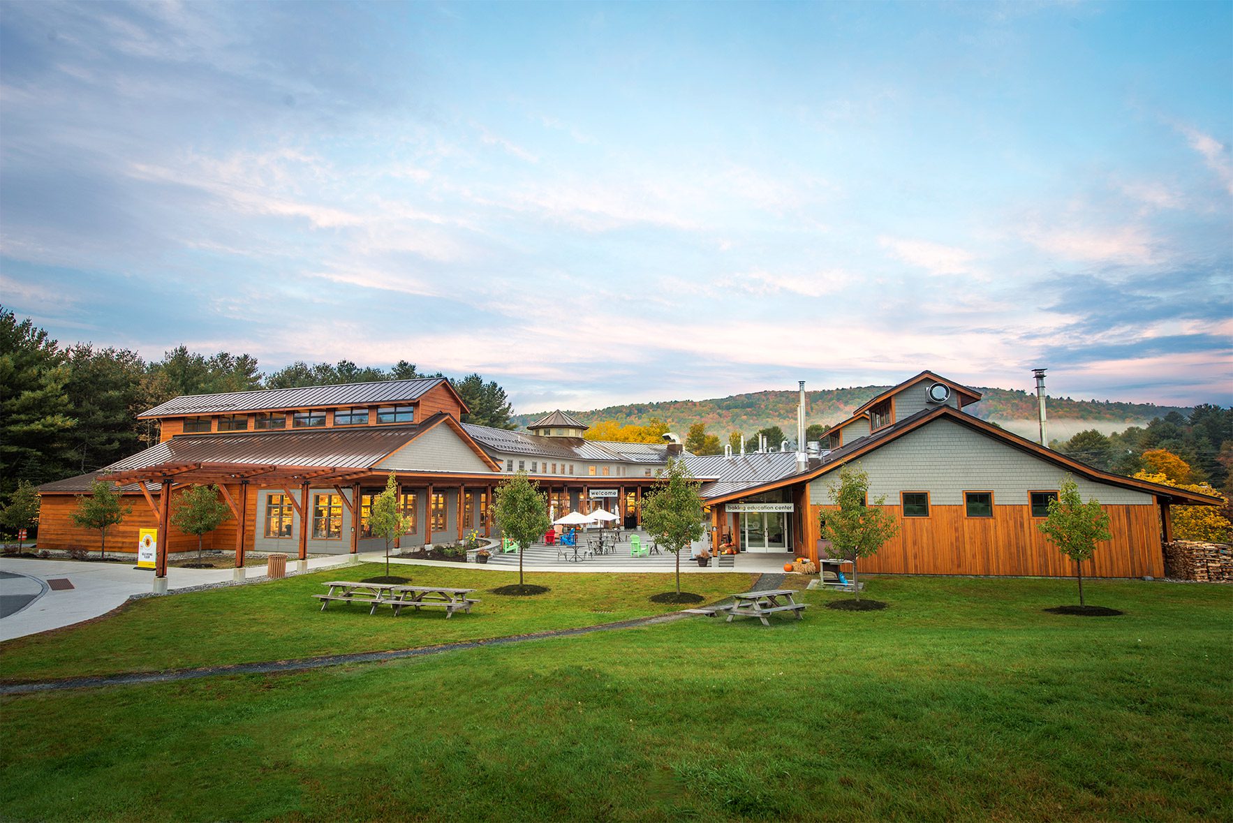 A wooden building with picnic tables on a sunny fall day.