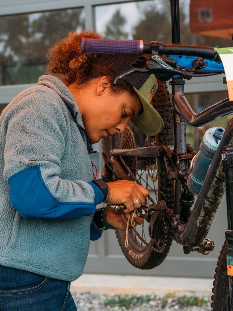 A person maintaining a bicycle outside.