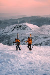 Two people skin up mansfield with skis.