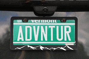 Close view of a green Vermont license plate that reads ADVNTUR.