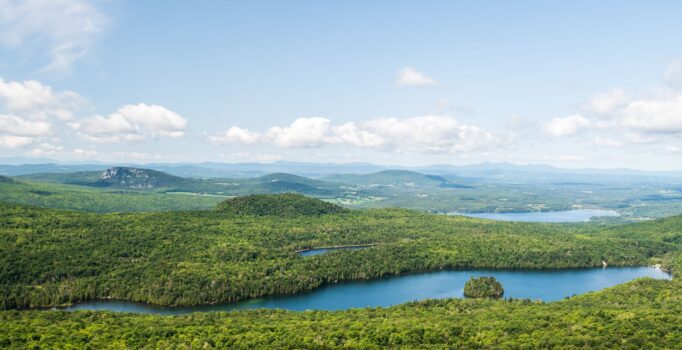 A scenic overlook of Vermont's green mountains and waterways.