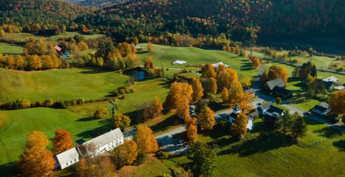 Seen from above, a sprawling mountain farm with green fields in the fall.