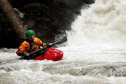 A person kayaks on a river.