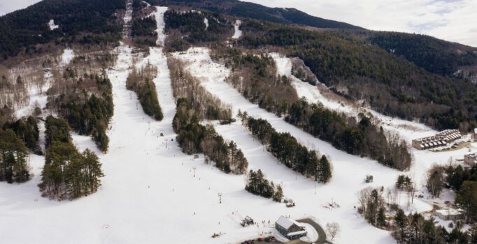 Seen from above, the ski trails of a small ski area are covered in snow.