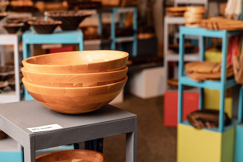 Hand crafted, wooden bowls are on display in a shop.