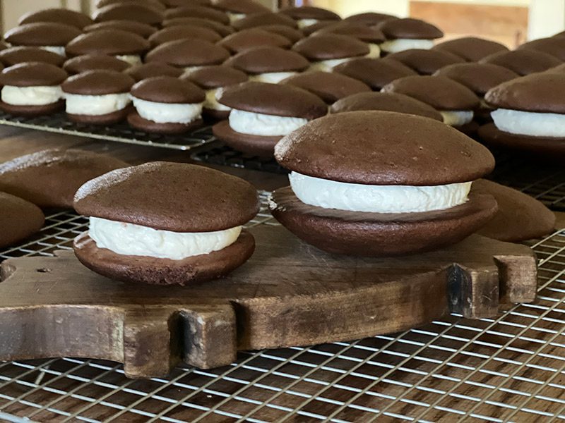 A selection of whoopie pies are displayed on a drying rack.