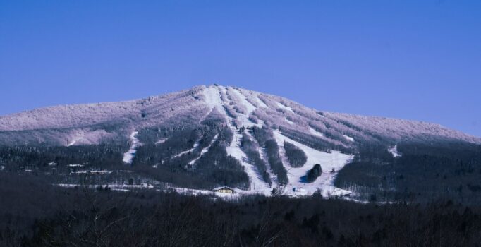 Seen from afar, a ski resort in the early hours of morning, with trails covered with snow.