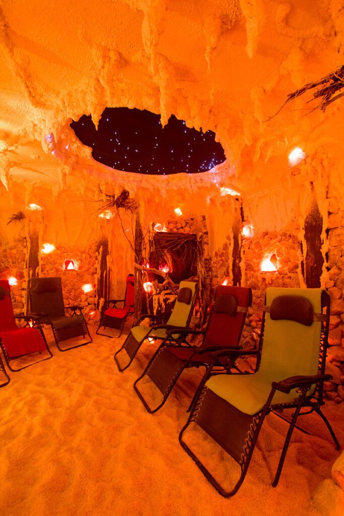 Multiple chairs are aligned in a room made from Himalayan salt.