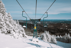 A green ski area lift covered in snow.