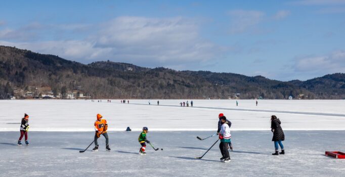 Children playing hockey on a lake in Vermont.