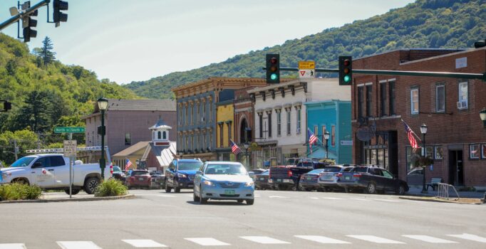 Colorful buildings line a street with cars in a rural downtown.