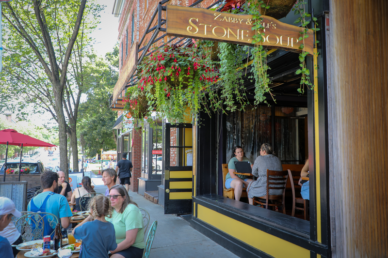 People dine outside at a restaurant in the summer. 