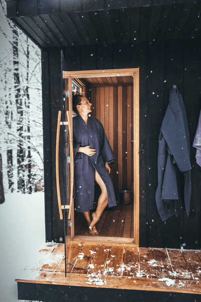 A person standing in the doorway of a sauna in Vermont.