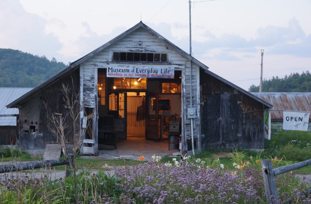 A rustic, weathered barn houses the