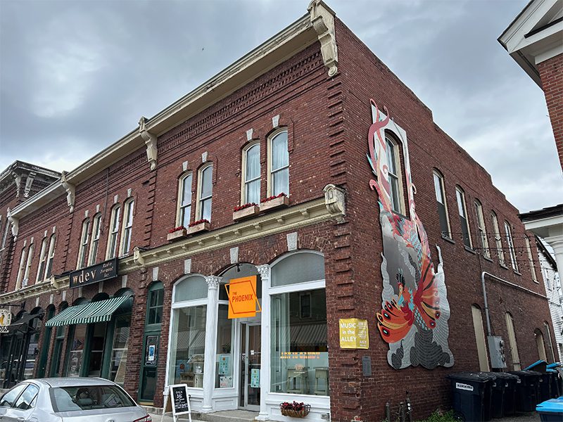 Historic red brick building with a colorful mural, featuring