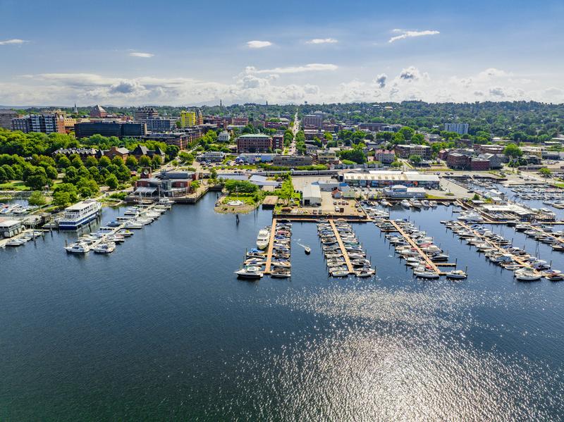 Seen from above, a historic downtown set next to a lake. Docks stretch into the water.
